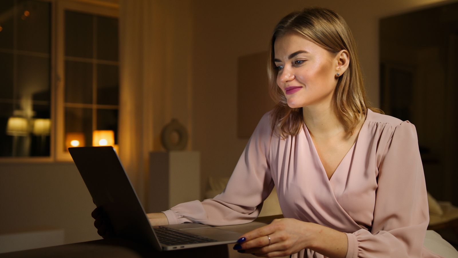 Osoba večer radi na laptopu kod kuće — posao sa strane uz redovno zaposlenje