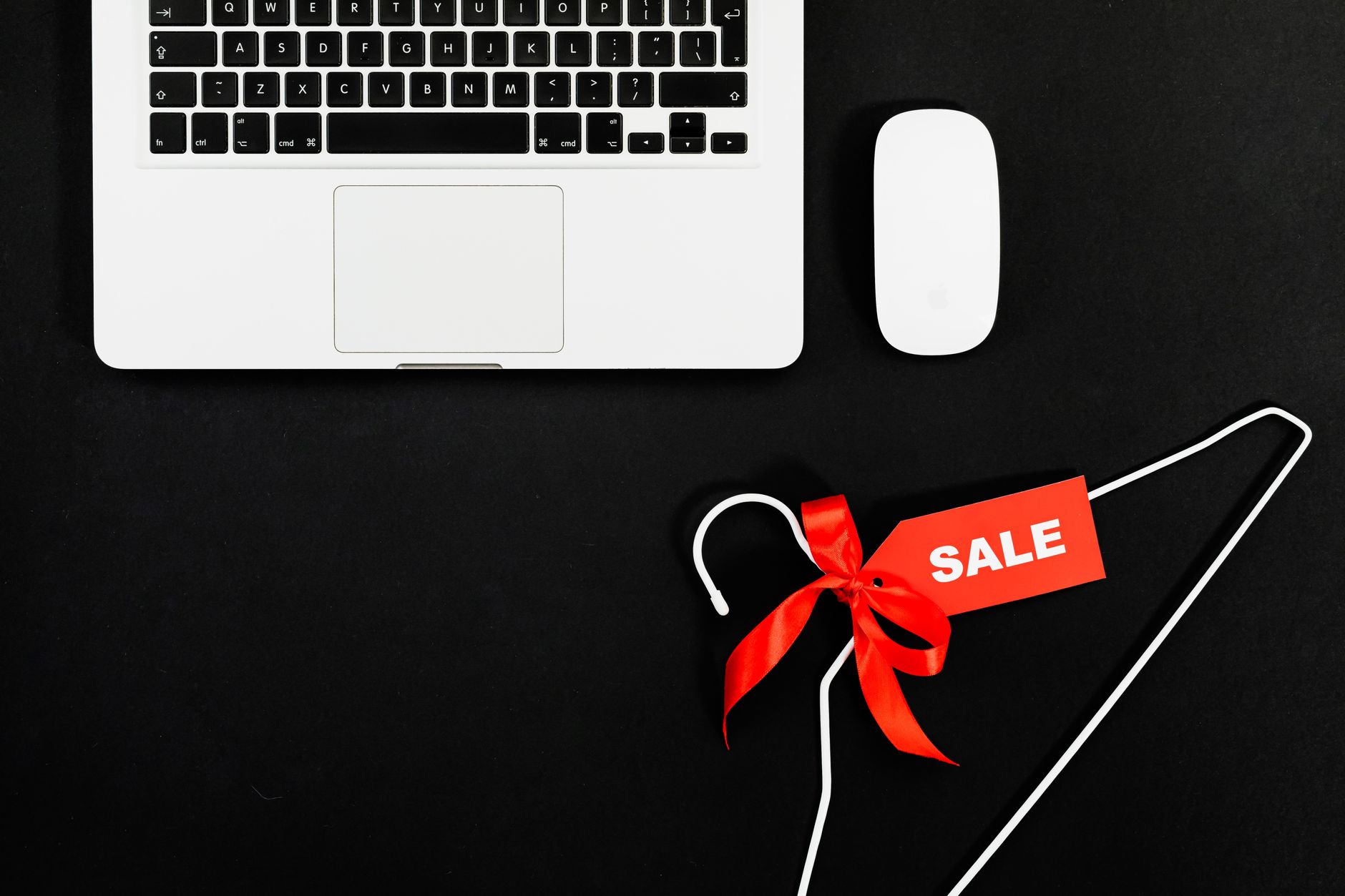 Prijenosno računalo i vješalica s oznakom sale — postavljanje oznake najniže cijene u 30 dana u webshopu